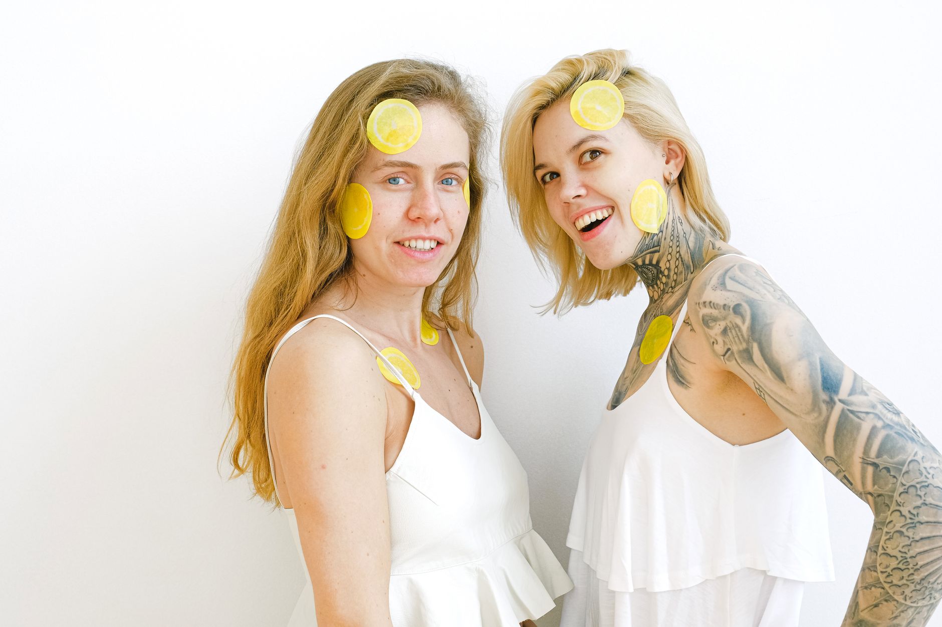 Women laughing together with fresh lemons, expressing joy and comfort