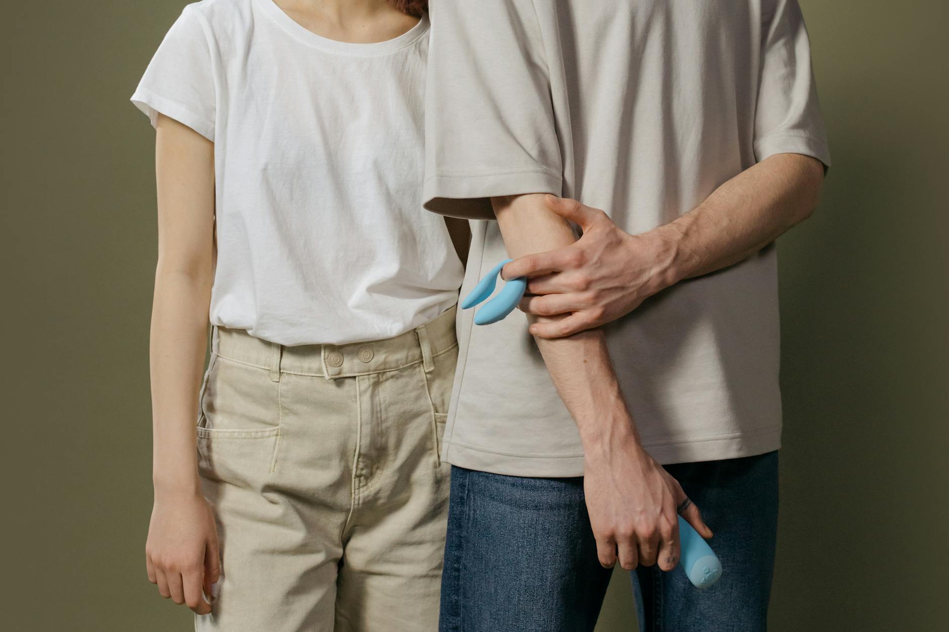 A couple holding a blue vibrator together, representing modern intimate pleasure and connection.