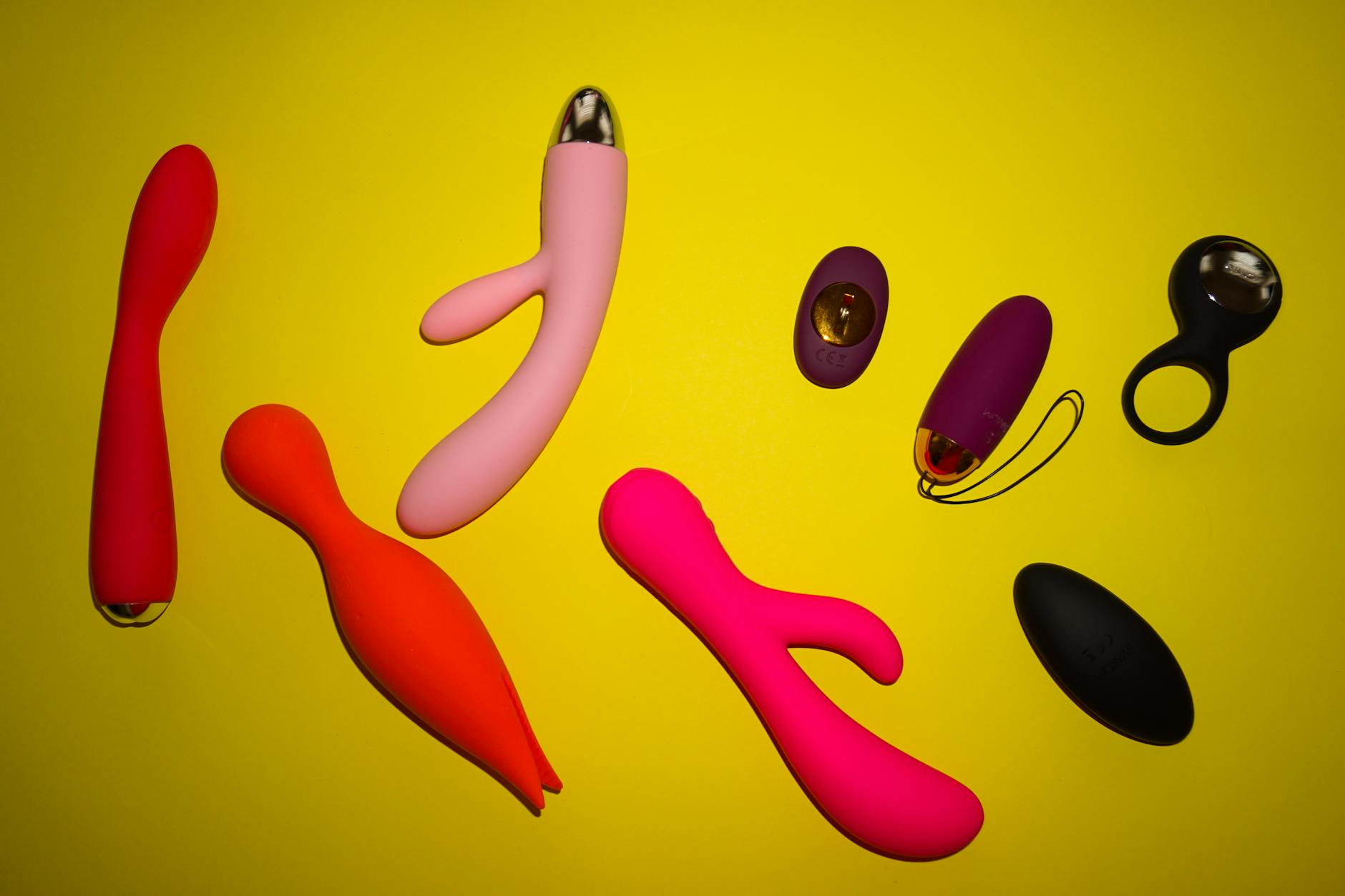 Hands holding pastel-colored silicone toys against a soft background